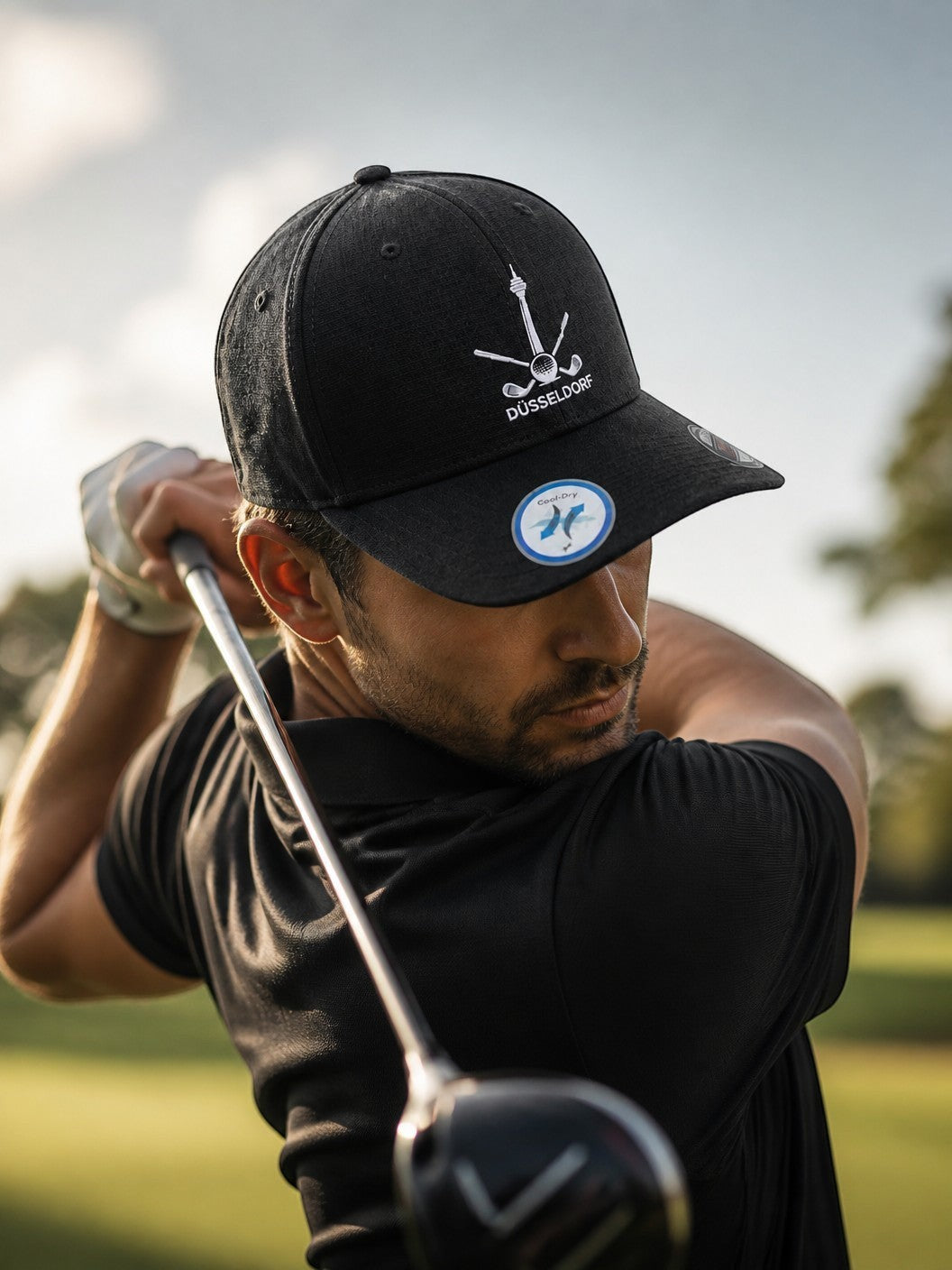 City Golf Shop Heimatgolf Flexfit Cap in Schwarz mit Düsseldorfer Rheinturm Stickerei bei einem Golfschwung