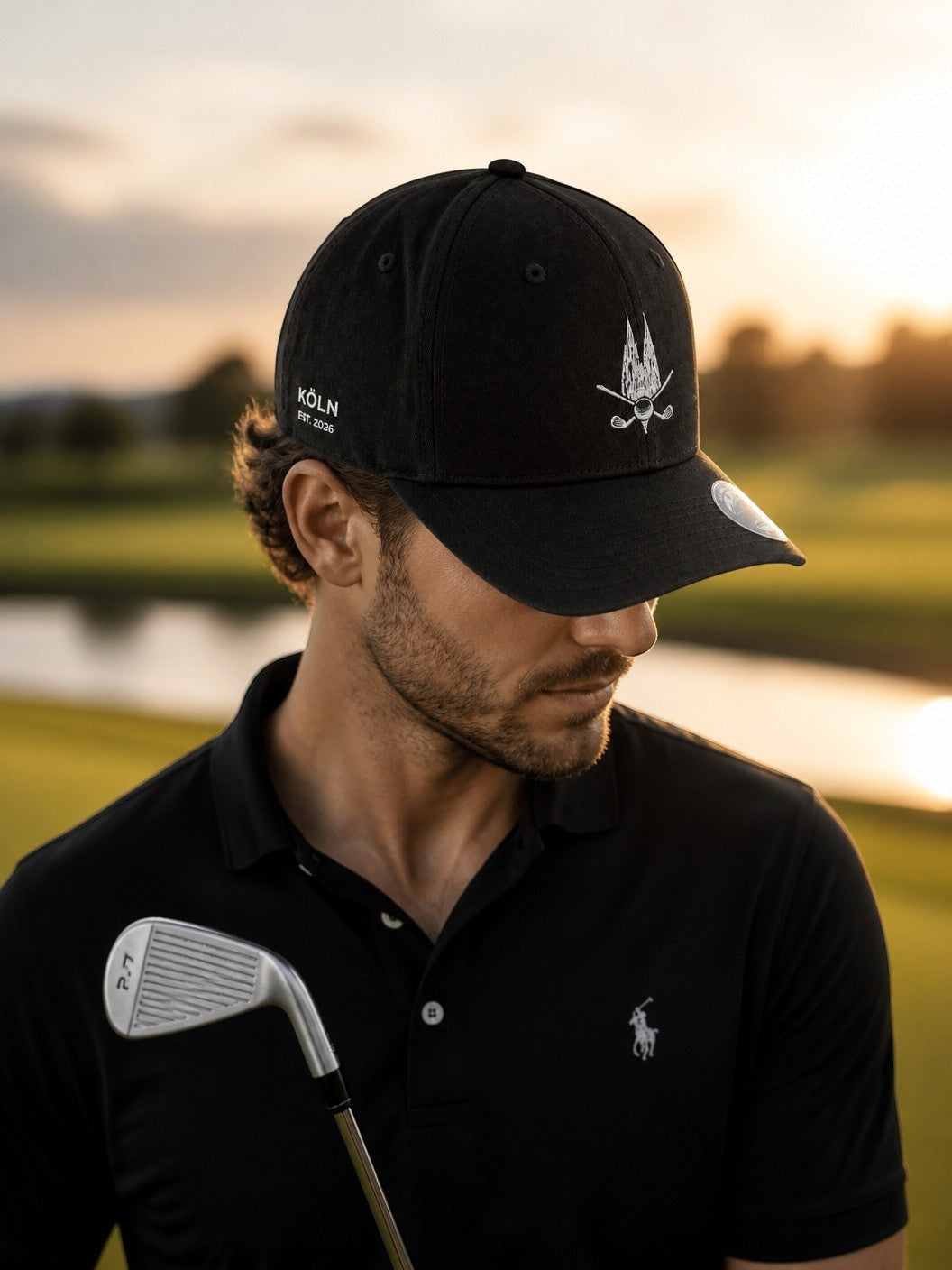 City Golf Shop Heimatgolf Flexfit Cap in Schwarz mit Kölner Dom Stickerei, getragen von einem Golfer bei Sonnenuntergang